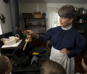 Docent shows children how Mrs. Eisenhower and other women cooked in the 1890s.