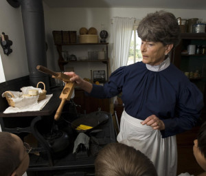 Docent shows children how Mrs. Eisenhower and other women cooked in the 1890s.