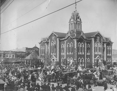 Hunt County Courthouse on San Jacinto Day 1917.  A record-breaking crowd gathered to hear Texas Governor James E. Ferguson speak as the large U. S. flag was raised over the courthouse.  Notice the over-whelming number of white males in the crowd.